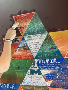 A collage of triangular prayer flags with quotes from poems written on them